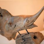 Holzfigur eines Fisches auf einem rustikalen Sockel