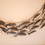 Metallkunstwerk mit Fischmotiven an der Wand