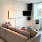 Wohnzimmer mit Sofa, Fernseher und modernem Kamin.