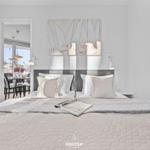 Schlafzimmer mit Bett, Wandbild und Blick in Essbereich.