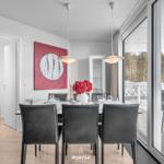 Esszimmer mit Tisch, Stühlen und Blick auf Terrasse.