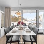 Esszimmer mit Tisch, Stühlen und Blick auf Balkon mit Schnee.