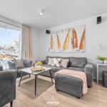 Wohnbereich mit grauem Sofa, Tisch und Blick auf verschneite Außenterrasse.