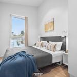 Schlafzimmer mit Bett, Fenster und Fernseher.