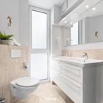 Badezimmer mit Doppelwaschbecken, Spiegelschrank und Toilette. Wanddekoration mit Seepferdchen.