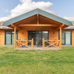 Holzhaus mit überdachtem Balkon, Garten und grünem Dach