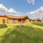 Holzhaus mit Grasdach und Terrasse im Grünen