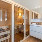 Sauna mit Holzverkleidung und Waschbecken mit Spiegel