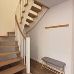 House with staircase, bench, and coat rack on the wall