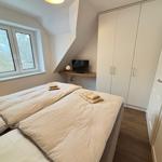 Bedroom with double bed, wardrobe, and window with view of trees.