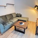 A living room with gray sofa, wooden table, and floor lamp.