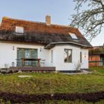 Wohnhaus mit Strohdach, Terrasse und Garten. Hausnummer 33. 