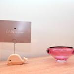 Willkommen-Schild auf Wal stand und rosa Glas schale auf Holztisch