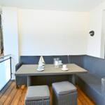 Terrasse mit Sitzgruppe, Tisch und Blick in den Wald.