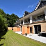 Moderne Villa mit Balkon, Terrasse und Garten. Holzgarage und Sitzgelegenheiten.