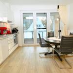 Küche mit Essbereich und Balkonansicht.