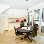 Küche und Essbereich mit runder Tisch und Stühlen. Durchgang zur Terrasse mit Glasfront.