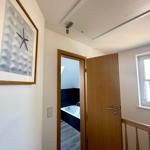 Flur mit Tür zum Bad und Fenster mit Blick auf Balkon