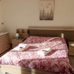 Schlafzimmer mit Bett, Nachttischen und Schrank. Auf dem Bett liegen Handtücher und Tulpen.