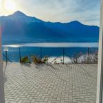 Terrasse mit Blick auf See und schneebedeckte Berge.