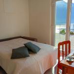 Schlafzimmer mit Blick auf See und Berge. Bett, Tisch und Stuhl sind vorhanden.