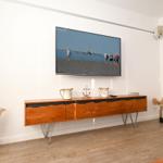 Wohnzimmer mit Fernseher, Holzboard und Dekoration.