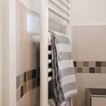 Dusche mit Handtuchhalter und gefliesten Wänden.