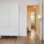 Schlafzimmer mit weißem Schrank und Tür zum Flur.