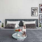 Schlafzimmer mit Bett, Kissen und Bildern an der Wand.