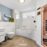 Badezimmer mit Dusche, Badewanne und integrierter Sauna.