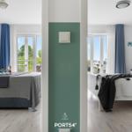 Zwei Schlafzimmer mit Balkon und Fenstern. Ein Raum hat gemusterte Wände.