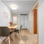 Essbereich mit Tisch, Stühlen und Blumen. Hintergrund: Bad und Schrank.