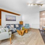 Wohn- und Essbereich mit Sofa, Sessel und Küchenzeile.