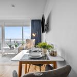 Essbereich mit Tisch und Stühlen, Blick auf Balkon mit Meerblick.