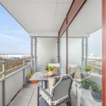 Terrasse mit Tisch, Stühlen und Blick auf Strand und Himmel