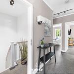 Flur mit Treppe, Schminktisch und Blick in Schlaf- und Wohnzimmer.