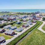 Dorf mit roten und blauen Häusern am Meer mit Kanal und Parkplatz.