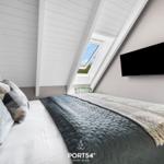 Schlafzimmer mit Dachschrägen, Dachfenster und Wandfernseher.