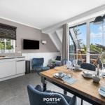 Küche und Esszimmer mit Tisch, Stühlen und Blick auf Balkon.