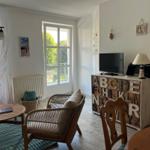 Wohnbereich mit Sitzgelegenheit, TV und Fenster zur Außenterrasse.