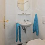 Badezimmer mit Waschbecken, Spiegel und blauen Handtüchern.