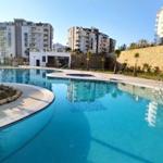 Großer Swimmingpool mit moderner Umgebung und mehreren Hochhäusern im Hintergrund.