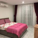 Schlafzimmer mit Bett, Vorhängen und Klimaanlage.