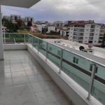 Terrasse mit Glasgeländer und Blick auf Stadt und Gebäude