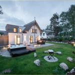 Moderne Villa mit Whirlpool, Grill und Garten. Umgeben von Bäumen und einem gepflegten Rasen.