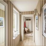Flur mit Streifenwand, Fenster, Bildern und Blick in Schlafzimmer mit Schrank und Stuhl.