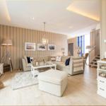 Wohnzimmer mit Sofa, Couchtisch und Fernseher. Wand mit Streifen, Treppenaufgang und Weinkühler.