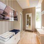 Flur mit gestreifter Tapete, Sitzbank und Wandbild mit Segelboot.