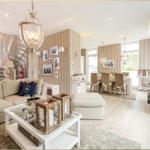 Wohn- und Essbereich mit Sofa, Esstisch und Kamin. Streifenwand und helles Holzfußboden.