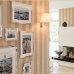 Wand mit gerahmten Bildern und moderner Kaminanlage mit schwarzer Arbeitsplatte.